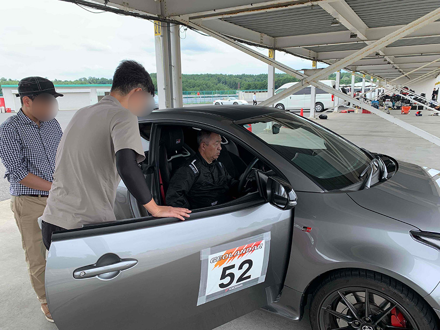 サーキット場でキネティックシートの試乗レビューに参加する様子。ドライバーへの身体的な負担感を軽減するため、シート生地の変更や、より安定した腰回りのホールド感になるような製品の提案を行った