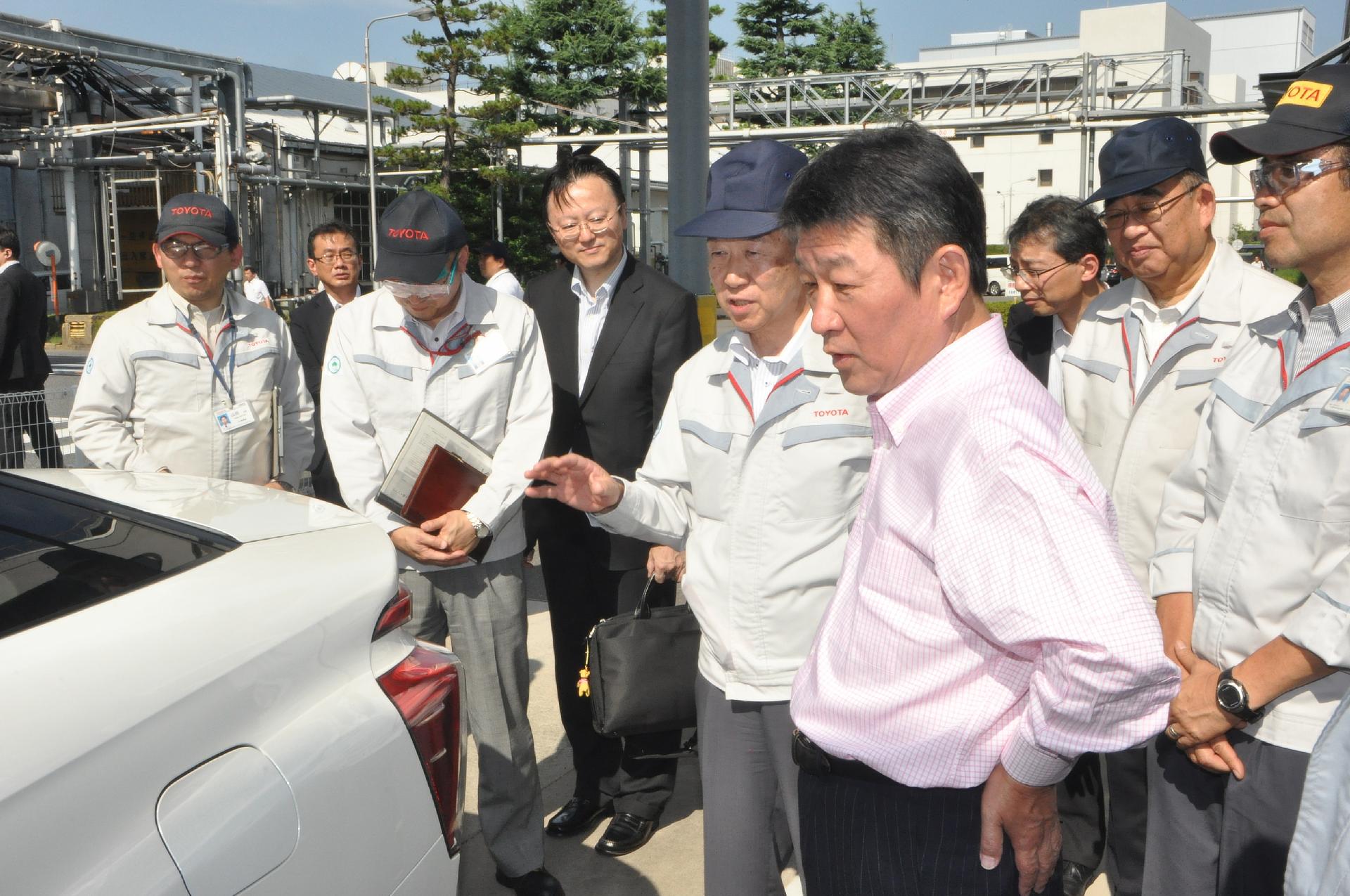 Mitsuhisa Kato, Toyota executive vice president (left foreground) and Toshimitsu Motegi, Japanese Minister of Economy, Trade and Industry (right foreground) pictured with Toyota's fuel cell sedan