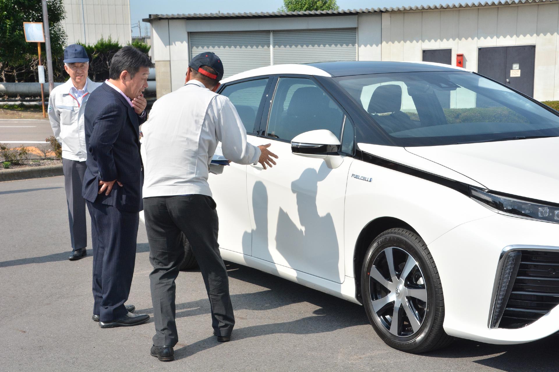 Mitsuhisa Kato, Toyota executive vice president (left) and Toshimitsu Motegi, Japanese Minister of Economy, Trade and Industry (middle) pictured with Toyota's fuel cell sedan