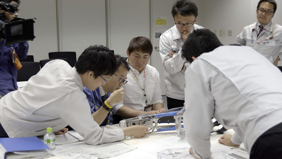Engineers engage in discussion over prototype model