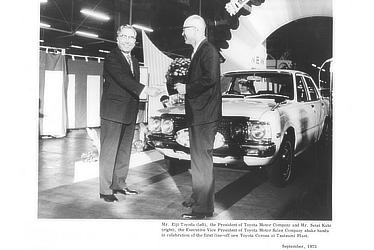 Mr. Eiji Toyoda (left), the President of Toyota Motor Company and Mr. Seisi Kato (right), the Executive Vice President of Toyota Motor Sales Company shake hands in celebration of the first line-off new Toyota Corona at Tsutsumi Plant.