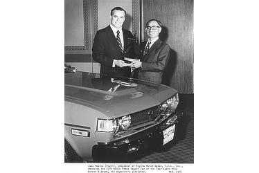 Isao Makino (right), president of Toyota Motor Sales, U.S.A., Inc., receives the 1976 Motor Trend Import Car of the Year Award from Robert E. Brown, the magazine's publisher.